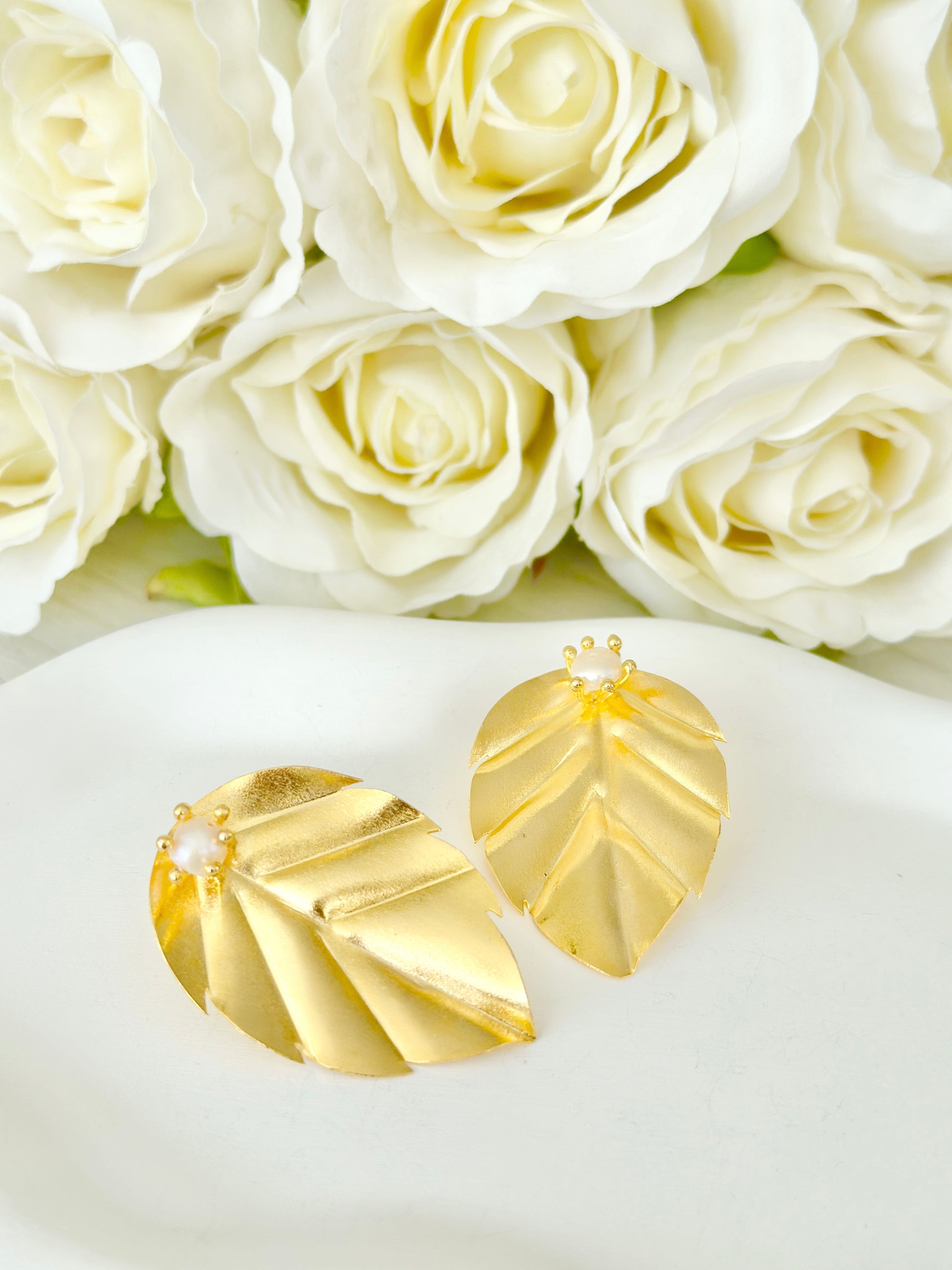 Aretes medianos en forma de hoja con perla central y baño de oro 24k